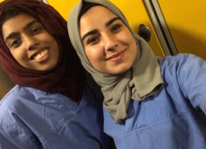 Image of two students in hospital scrubs