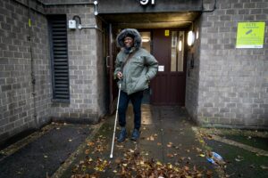 Image of a blind person outside their home