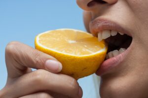 Image of a person eating a lemon